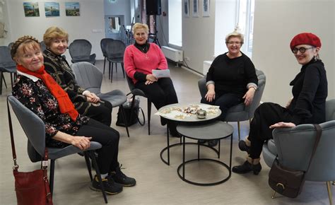 Grupė žmonių diskutuoja apie knygą knygų klube, rodant socialinę sąveiką