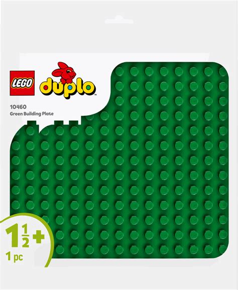 Vaikas statantis LEGO miestą ant žalios pagrindo plokštės