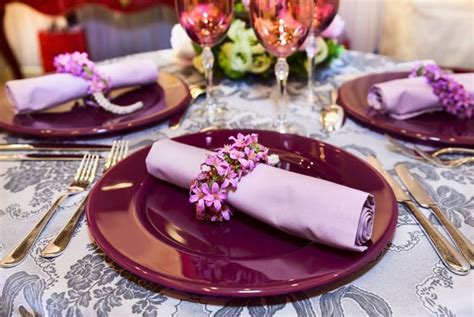 Stalo serviravimas su rožinėmis servetėlėmis ir gėrimų šiaudeliais