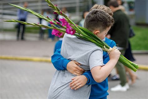 Šeima bendrauja su mokytoju mokyklos aplinkoje