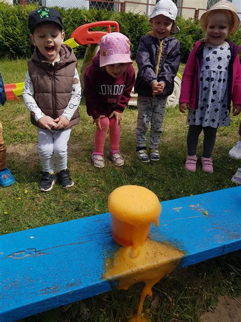 vaikai atliekantys STEAM eksperimentą su spalvotu vandeniu