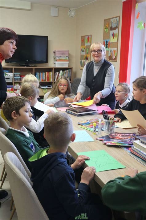 Pedagogė su vaikais aptaria knygos turinį edukaciniame užsiėmime