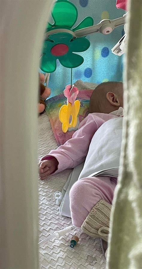 Kūdikis gulintis ant tėvo kelių, pasiruošęs atsirūgti