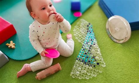 Kūdikis žaidžia su lavinamaisiais žaislais