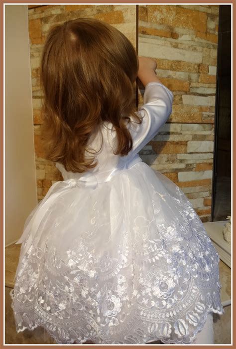 mergaitė su gražia krikšto suknele