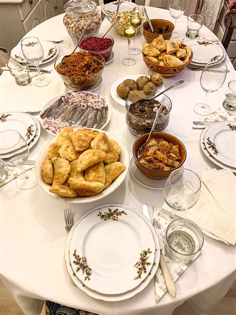 jaukus Kūčių stalas su žvakėmis ir tradiciniais patiekalais