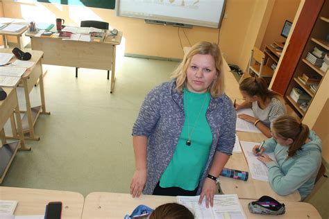 mokytoja dirbanti su planšete klasėje