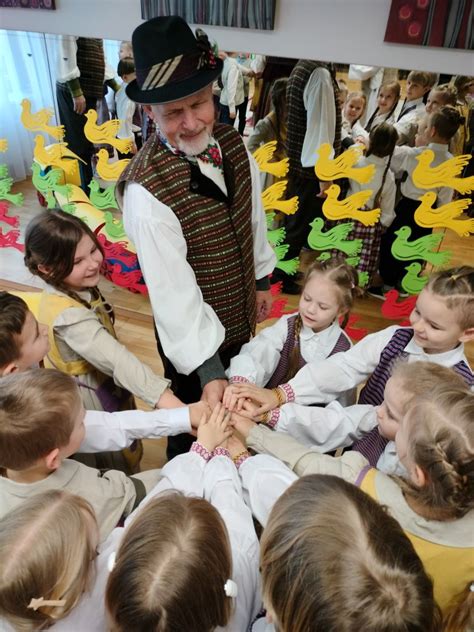Vaikai švenčia kalendorinę šventę, pasipuošę tautiniais elementais