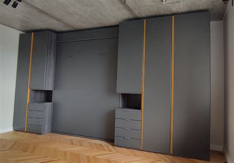 minimalistinė sieninė spinta su integruota lova