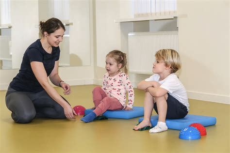 Kineziterapeutė atlieka masažą kūdikiui