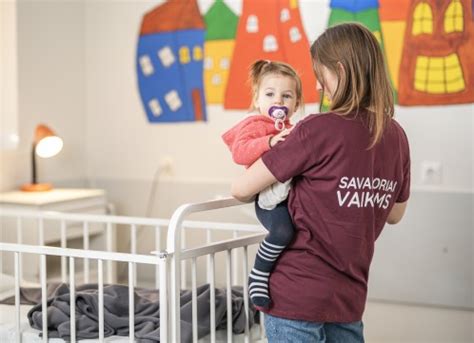 Vaikas ligoninės palatoje su savanoriu