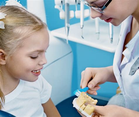 Vaikų odontologas bendrauja su vaiku odontologijos kabinete