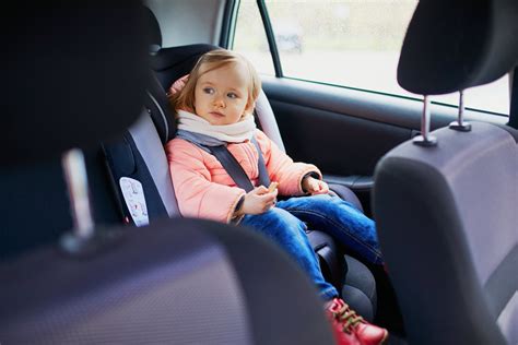 vaikas automobilinėje kėdutėje priekinėje sėdynėje