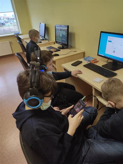 Vaikai dirba su robotais ir kompiuteriais edukacinėje stovykloje