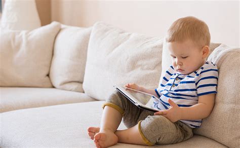 vaikas žiūri į planšetę