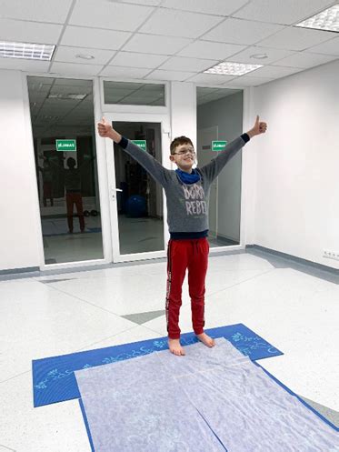 vaikas atlieka pratimus su kineziterapeutu