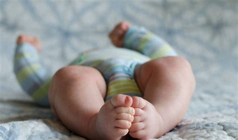 Kūdikis atliekantis mankštos pratimus namuose ant kilimėlio