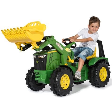 Vaikas žaidžiantis su John Deere traktoriumi