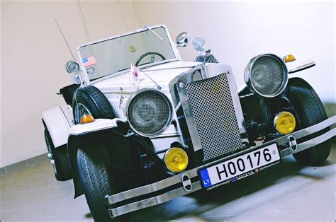 Senovinių automobilių lenktynių iliustracija kaimo kelyje