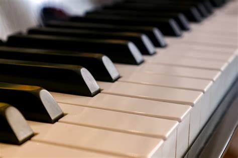 Vaikas, besimokantis groti pianinu pagal natas