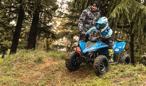 Vaikas, važiuojantis pedaliniu keturračiu lauke