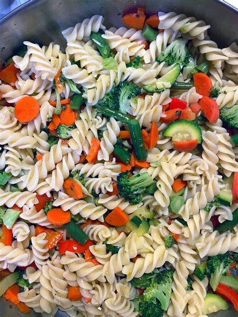 Vaiko rankos maišančios makaronus su daržovėmis