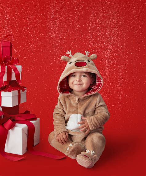 Kūdikis su kalėdiniu bodžiuku prie eglutės