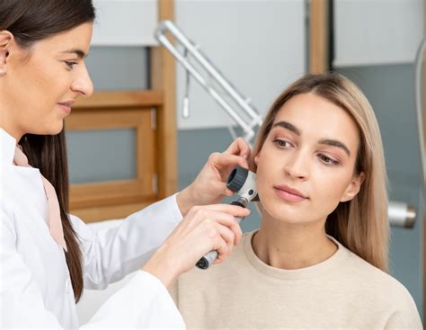 Dermatologo konsultacija su pacientu, tiriant galvos odą dermatoskopu