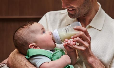tėtis maitina kūdikį iš buteliuko