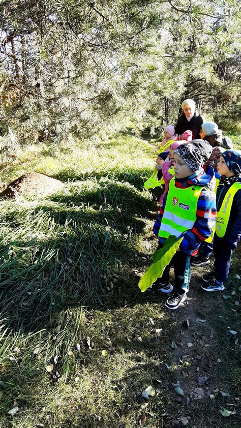 Vaikų ekskursija prie upės su šviesą atspindinčiomis liemenėmis