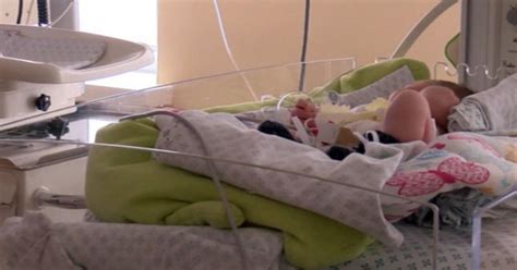 Naujagimis inkubatoriuje su medicininiais prietaisais