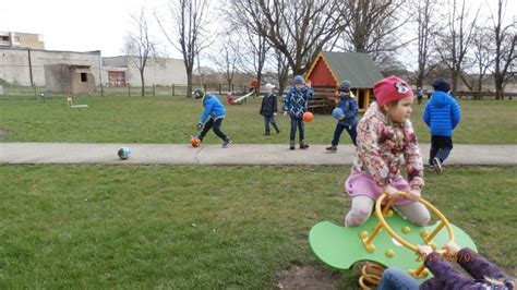 Vaizdas su vaikais, žaidžiančiais įvairius sportinius žaidimus lauke