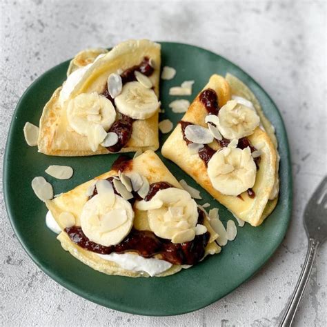 lėkštė su gardžiais, ką tik iškeptais bananų blyneliais, papuoštais šviežiais vaisiais