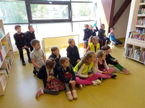 Grupė vaikų dainuoja su mokytoja