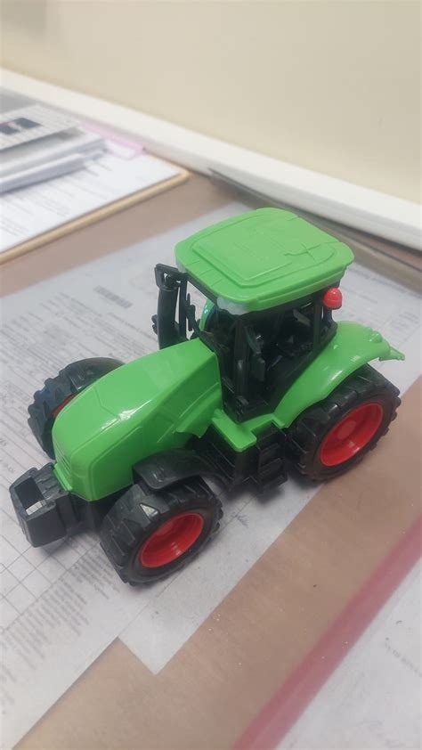 Vaikas vairuoja žaislinį traktorių John Deere