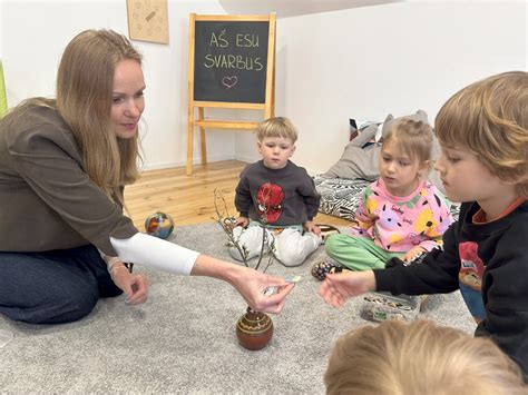 Vaikai grupėje dainuoja su mokytoja