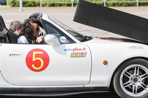 lenktynininkas prie sportinio automobilio vairo trasoje
