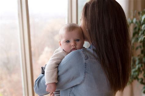 Mama su kūdikiu nešioklėje