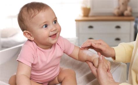 Mama tepa kūdikio veiduką apsauginiu kremu