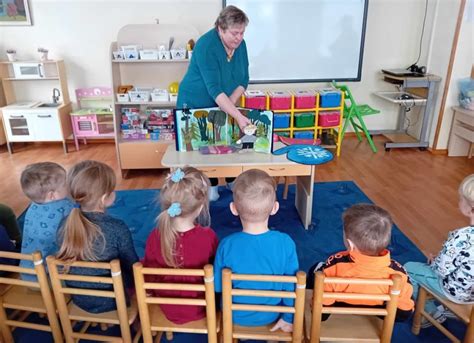mokytojas bendrauja su vaikais darželyje