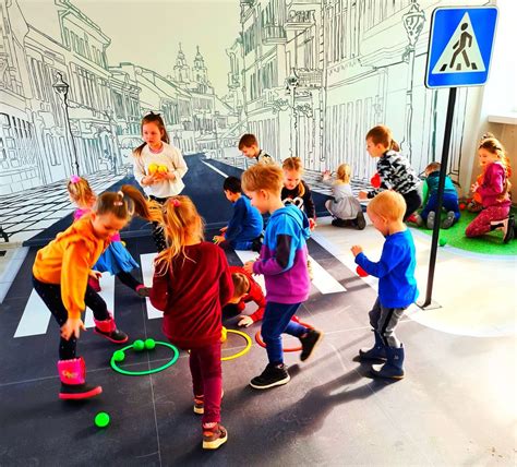 Vaikai žaidžia ir mokosi saugaus elgesio su mokytoju lauko aplinkoje