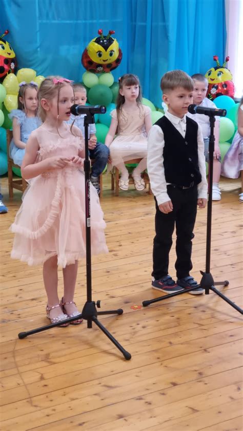 Vaikai su kepuraitėmis ir diplomais išleistuvių šventėje