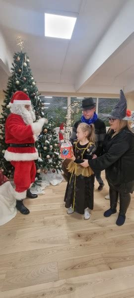 vaikai džiugiai laukia Kalėdų senelio su dovanomis