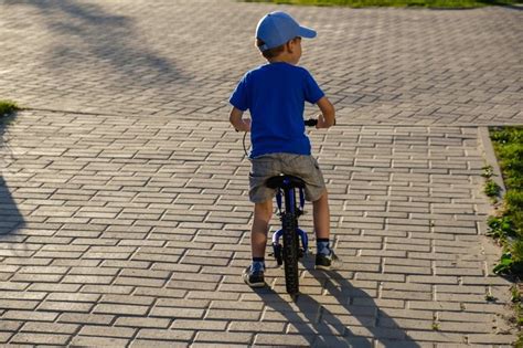 vaikas važiuoja balansiniu dviračiu parke