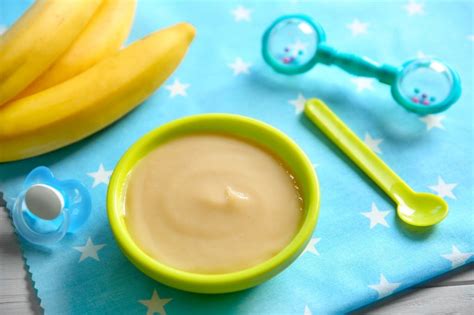 Kūdikis valgo trintą bananą šaukšteliu