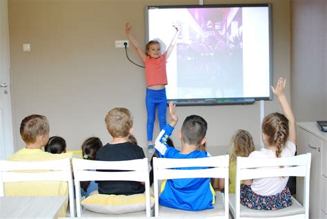 Džiaugsmingi vaikai žaidžia darželio kieme