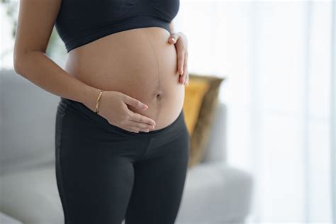 Nėščia moteris masažuojanti pilvą