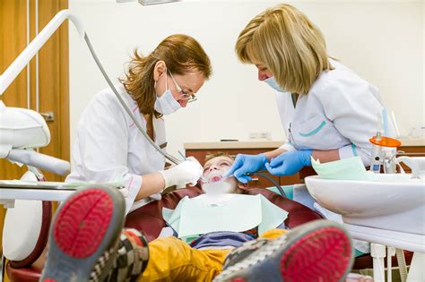 Odontologijos studentai dirbantys su vaikais