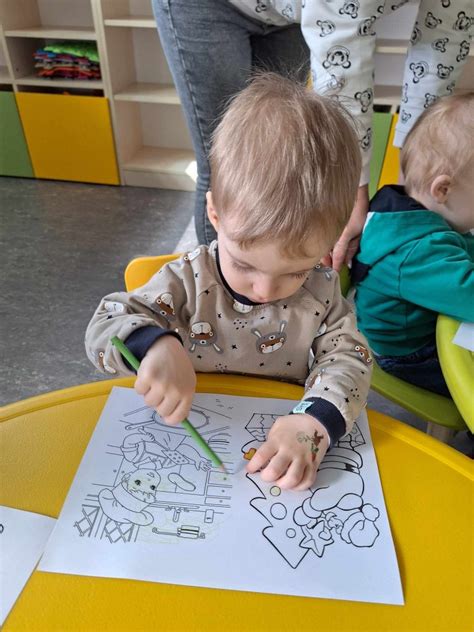 Vaikas su tėvais prie darželio, besiruošiantis adaptacijai