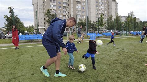 Vaikai atliekantys tempimo pratimus futbolo aikštelėje